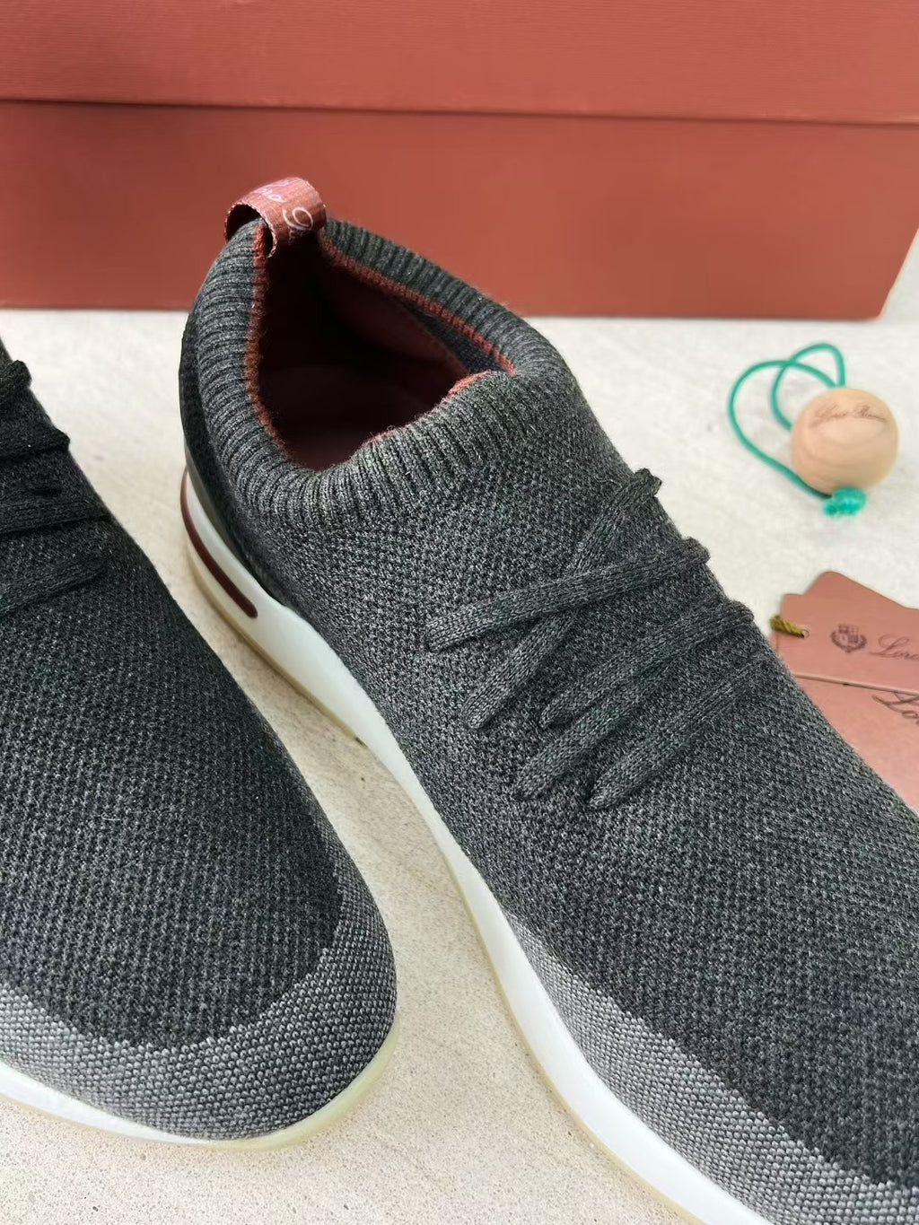 Loro Piana – Schwarze Strick-Sneaker mit geprägter Sohle und bordeauxfarbenem Akzent