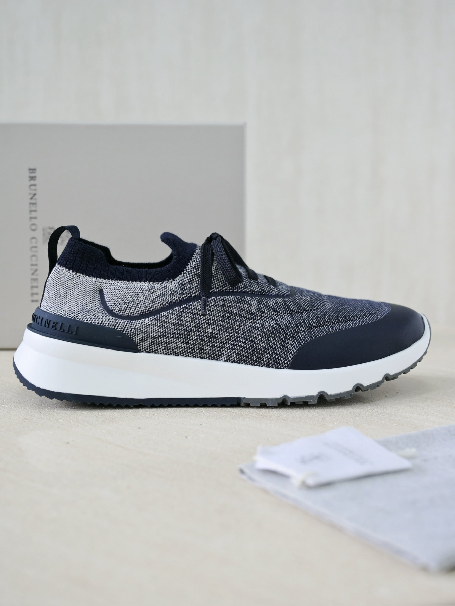 Brunello Cucinelli Herren Sneaker aus grauem Strickmaterial mit dunkelblauen Lederdetails und Gummisohle