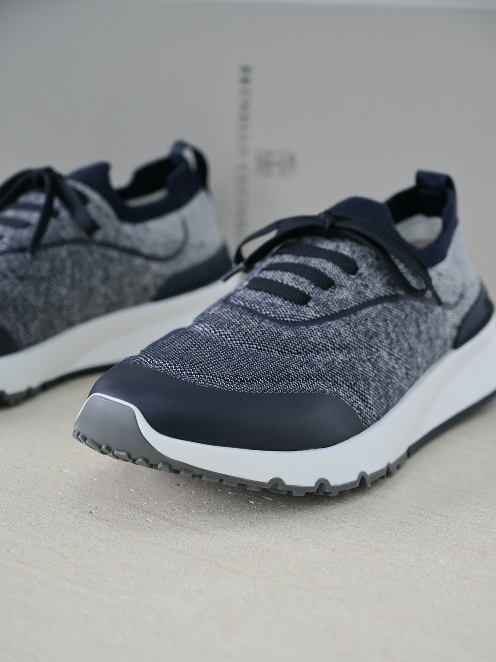 Brunello Cucinelli Herren Sneaker aus grauem Strickmaterial mit dunkelblauen Lederdetails und Gummisohle