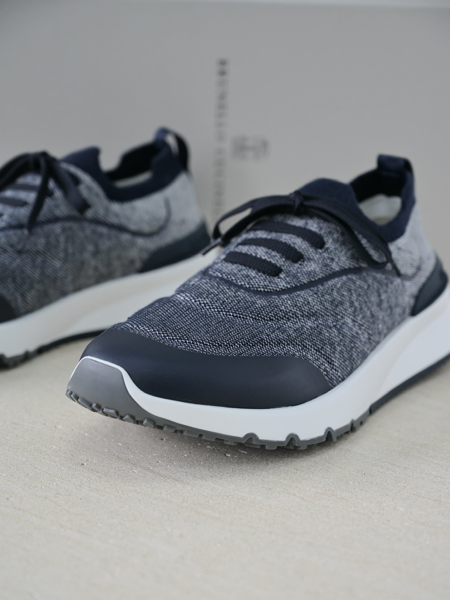 Brunello Cucinelli Herren Sneaker aus grauem Strickmaterial mit dunkelblauen Lederdetails und Gummisohle