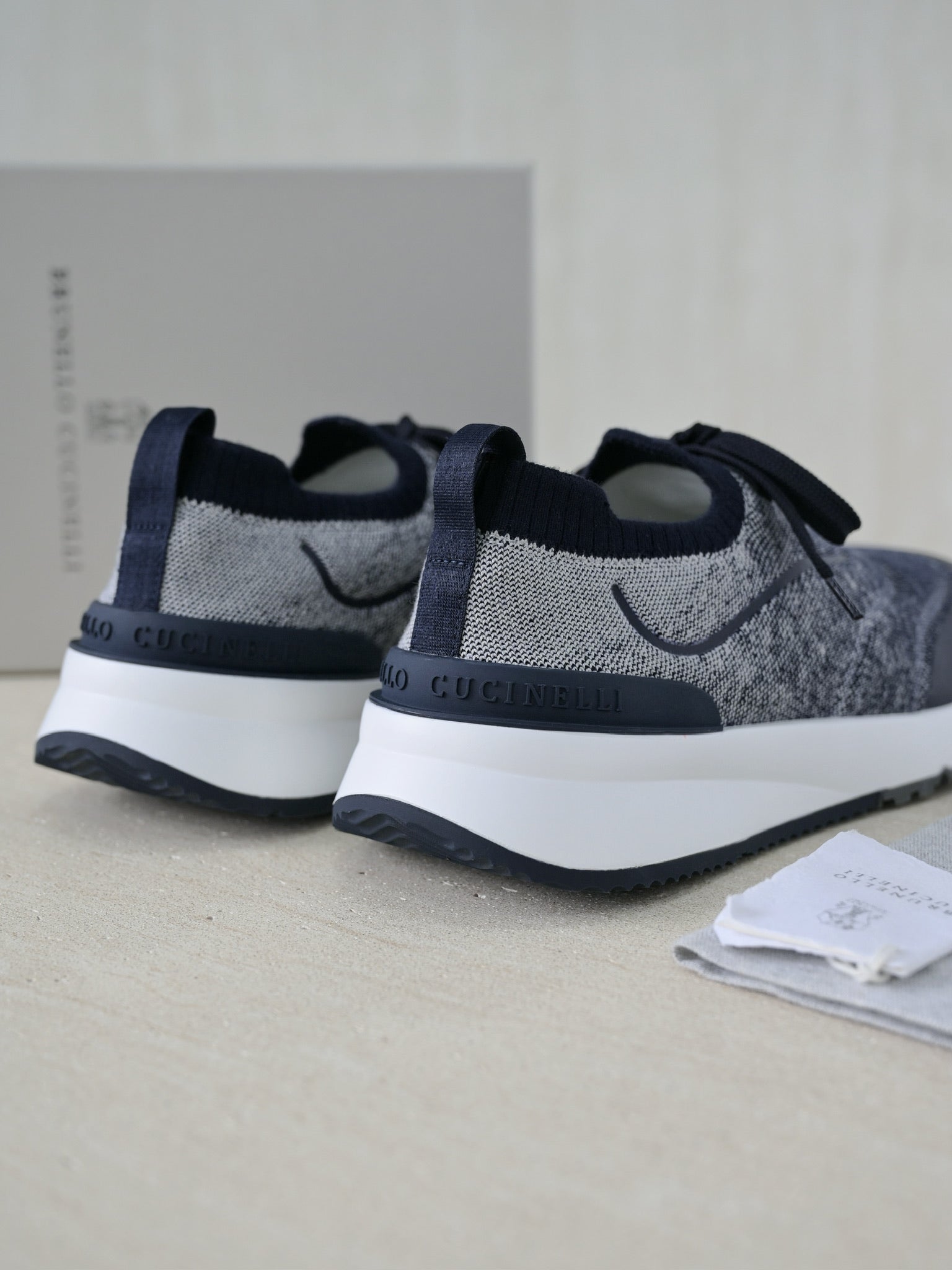 Brunello Cucinelli Herren Sneaker aus grauem Strickmaterial mit dunkelblauen Lederdetails und Gummisohle