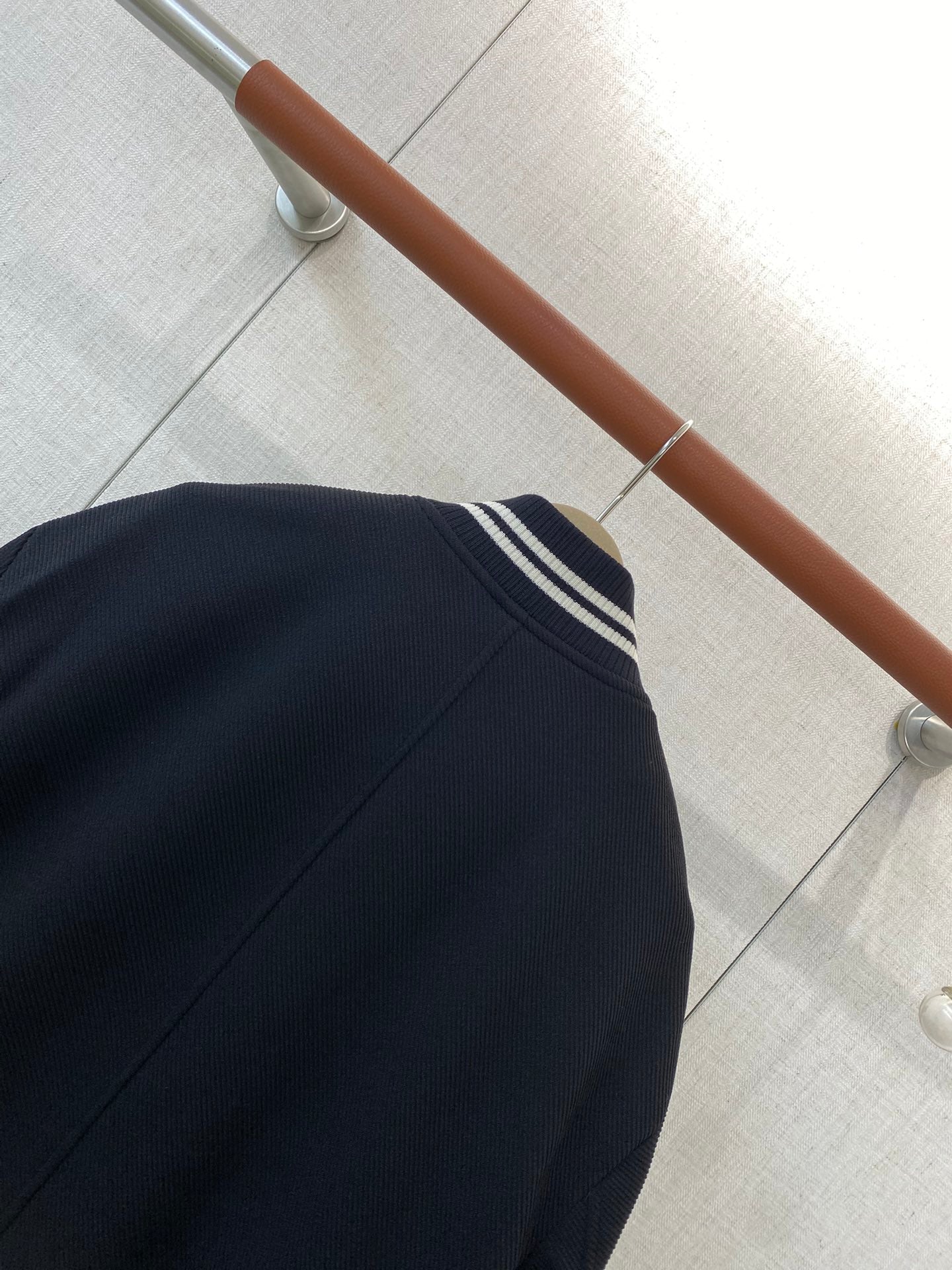 Loro Piana Dunkelblaue Collegejacke aus Wollmix mit gestreiften Rippbündchen