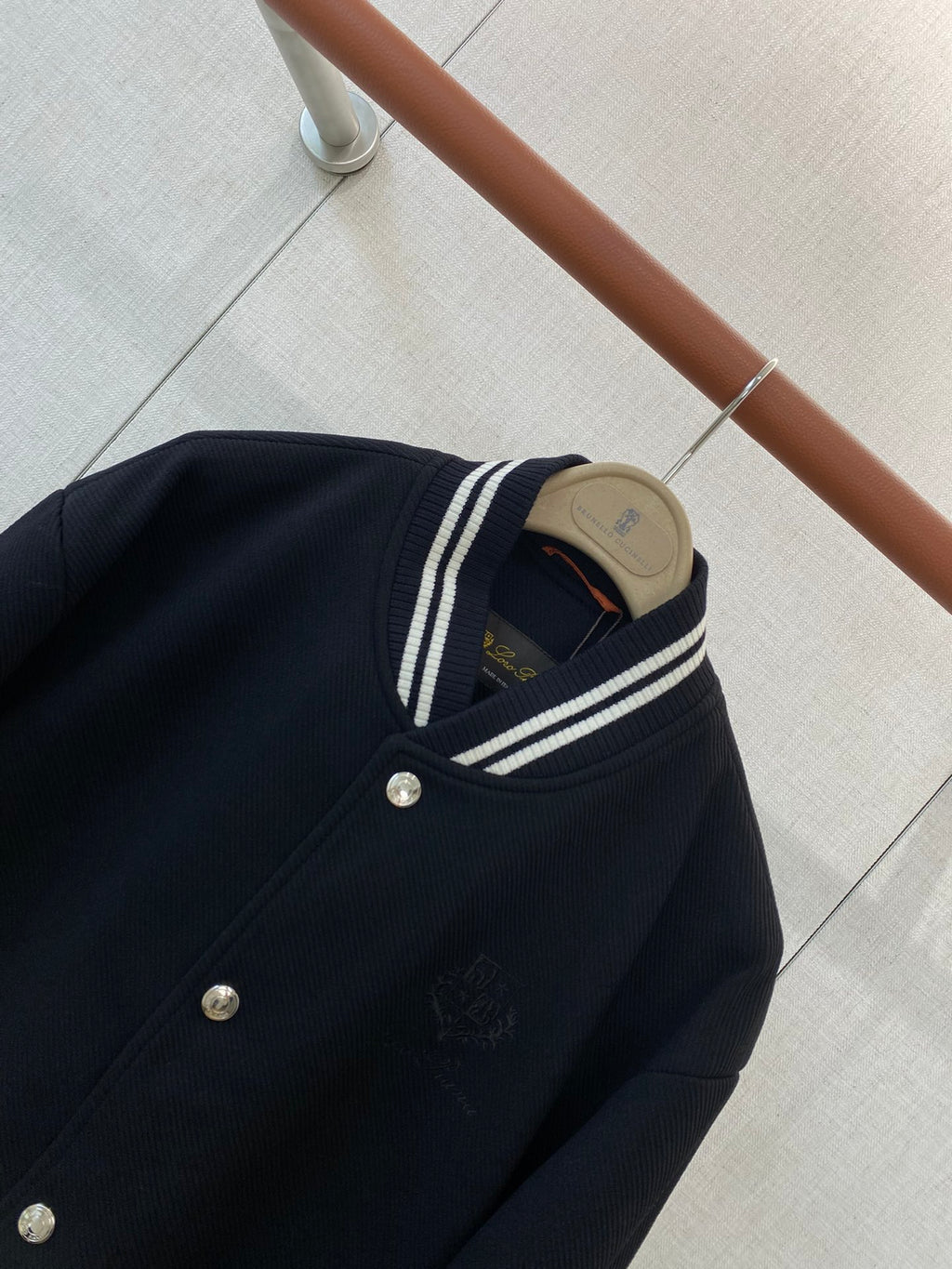 Loro Piana Dunkelblaue Collegejacke aus Wollmix mit gestreiften Rippbündchen